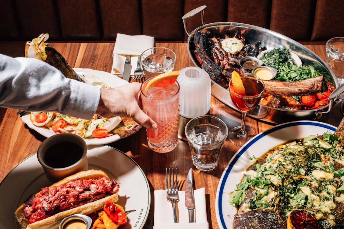 a group of people sitting at a table with a plate of food